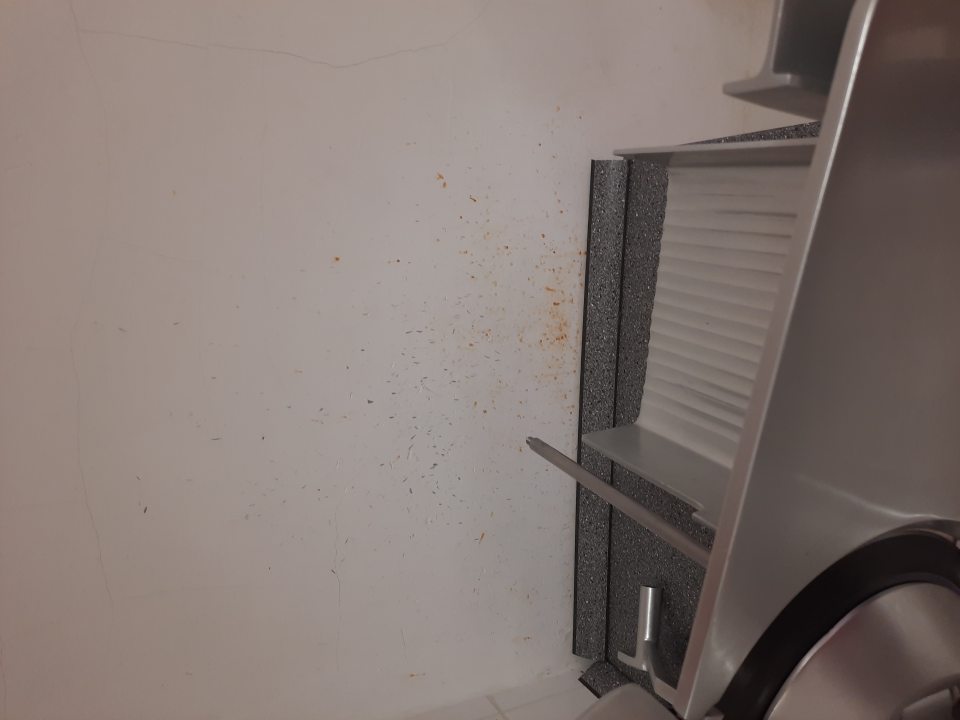 Znečistená ťažko čistiteľná stena pri krájači mäsových výrobkov