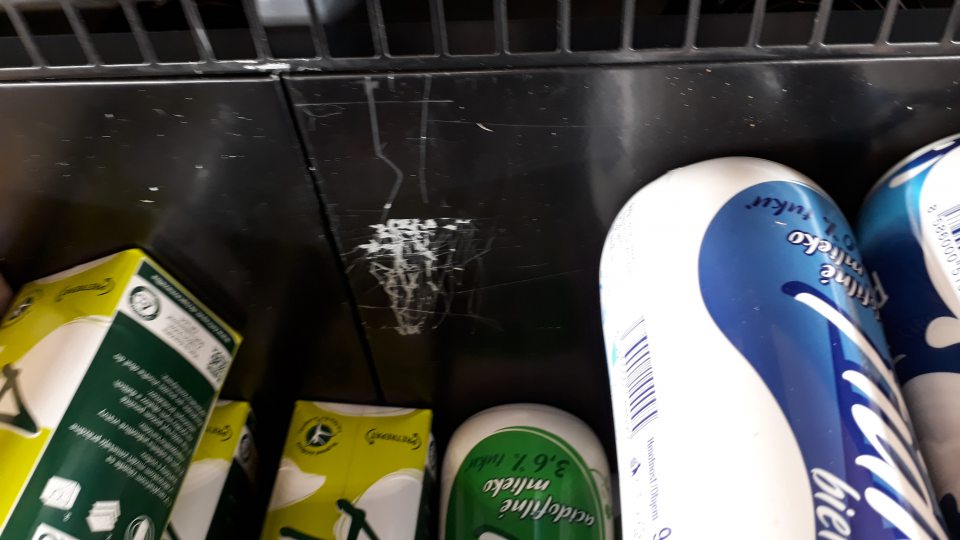 Poškodená úložná plocha v chladiacej vitríne pre mliečne výrobky.