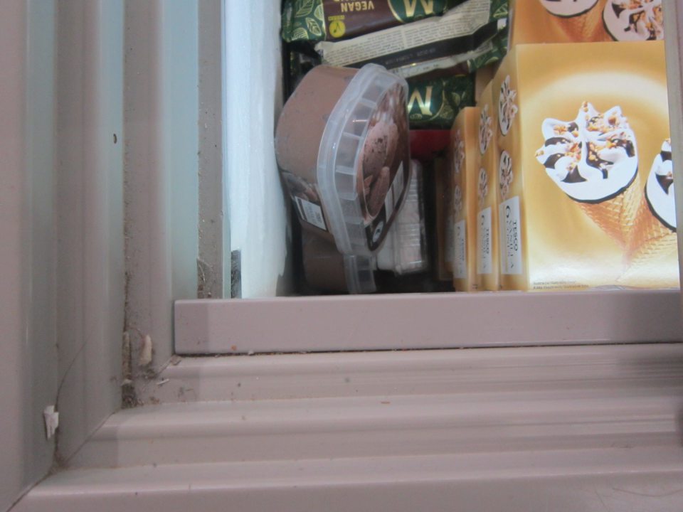 Na predajnej ploche v mraziacom zariadení znečistené vrchné vodiace lišty nánosom prachu a nečistotami. 