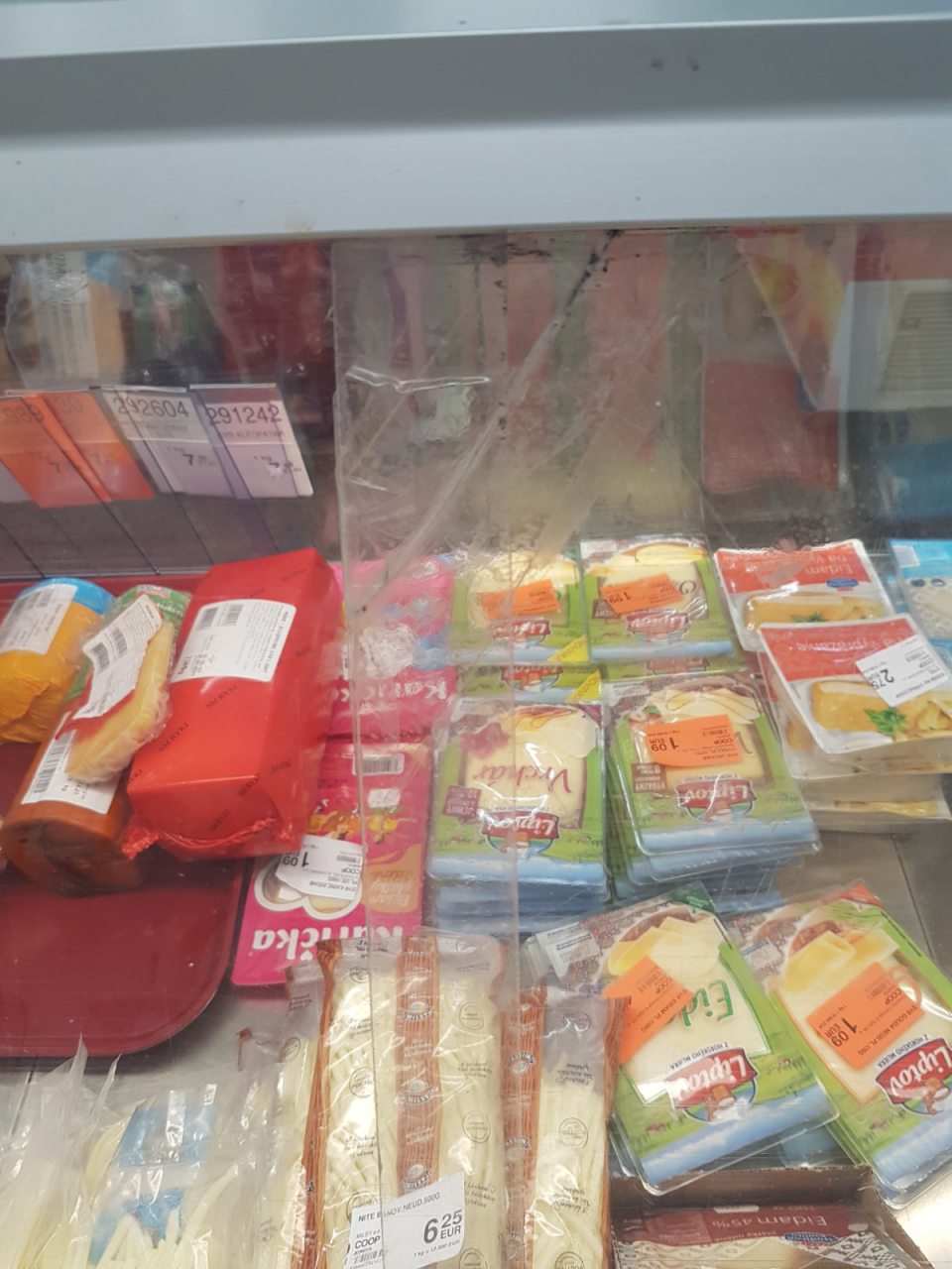 Poškodené a prasknuté plastové dvierka chladiaceho pultu s mäsovými výrobkami v predajni