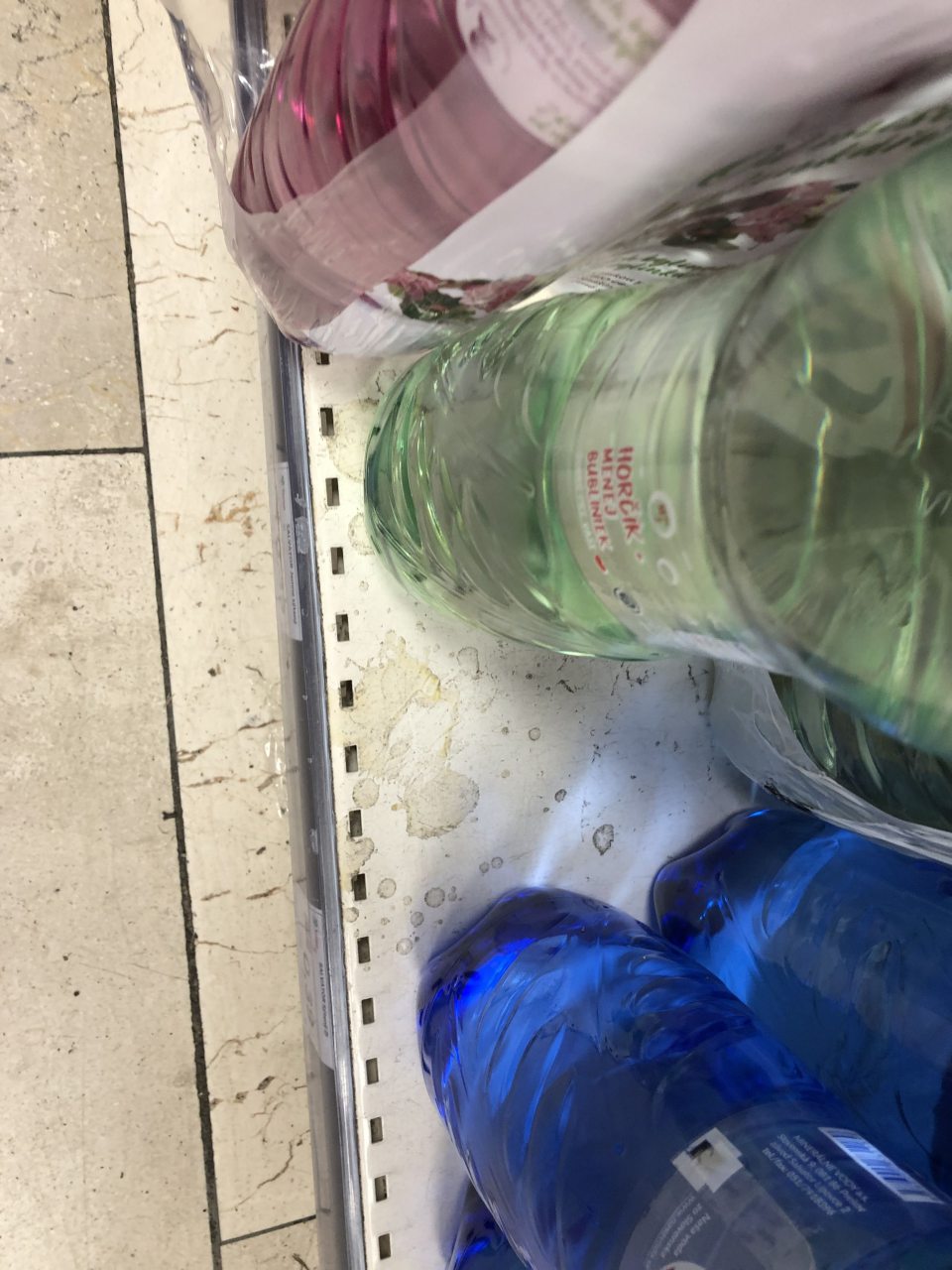 Predajňa- znečistené regále so sladenými sýtenými nápojmi a minerálnymi vodami