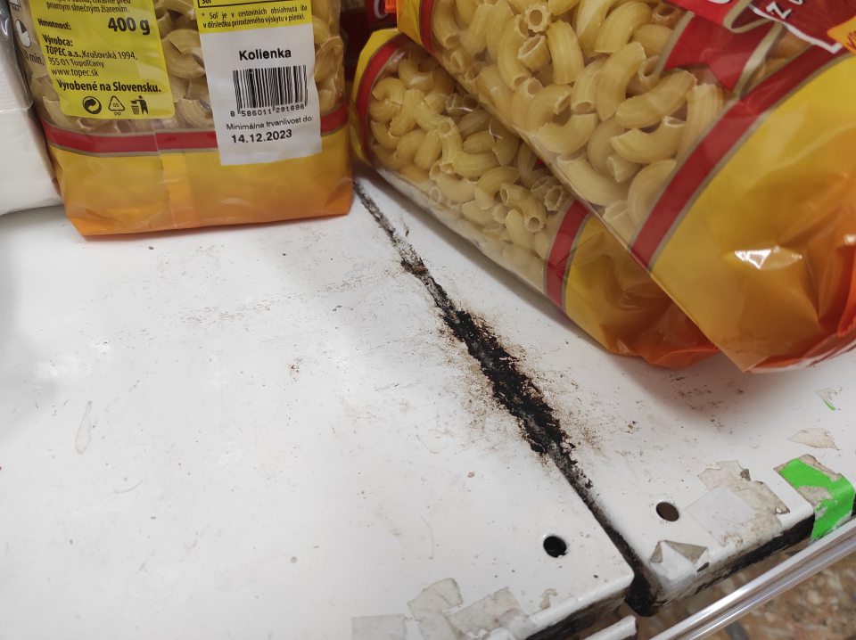 Poškodená ochranná sieťka proti škodcom na dverách slúžiacich na príjem tovaru.