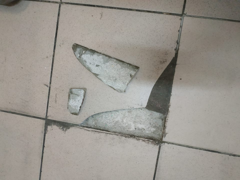 Poškodená podlaha v priechodnej časti skladového priestoru .