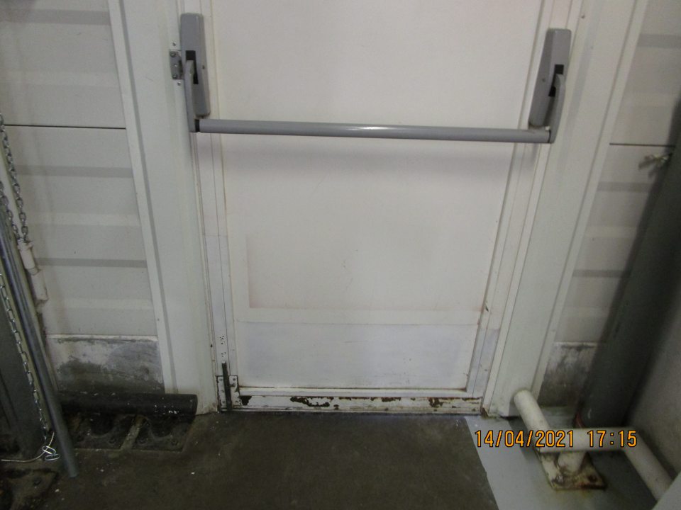 v zázemí prevádzky na bočných vstupných dverách z vnútornej strany v spodnej časti značne skorodovaná časť dverí a znečistená podkaha nánosom prachu a nečistôt na ťažko dostupnom mieste za rúrou vedľa príjmu potravín cca 80x12 cm