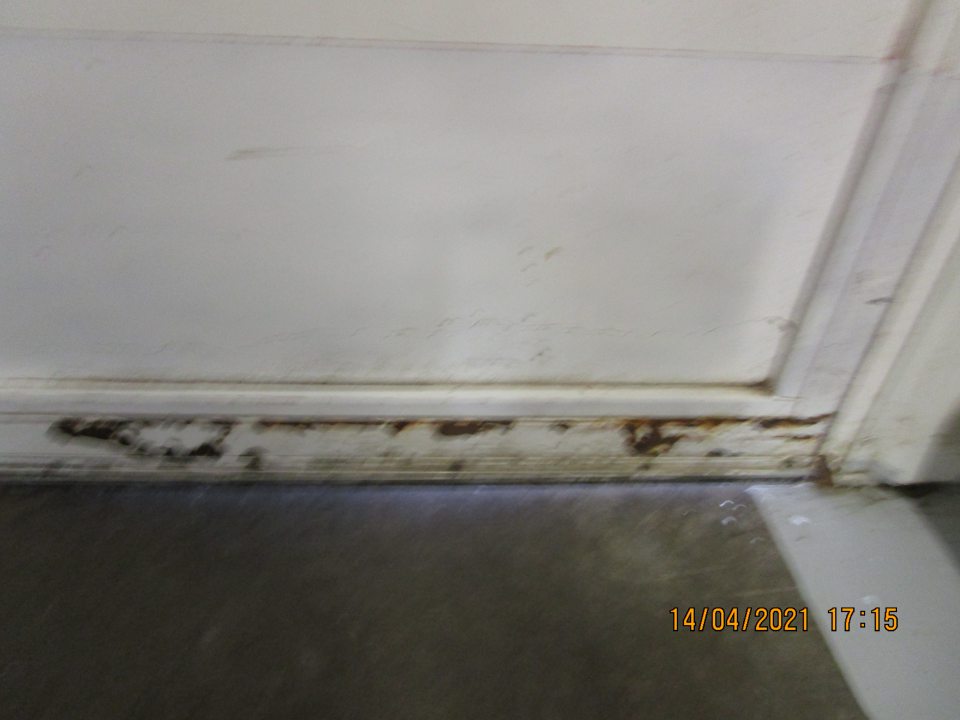 v zázemí prevádzky na bočných vstupných dverách z vnútornej strany v spodnej časti značne skorodovaná časť dverí a znečistená podkaha nánosom prachu a nečistôt na ťažko dostupnom mieste za rúrou vedľa príjmu potravín cca 80x12 cm