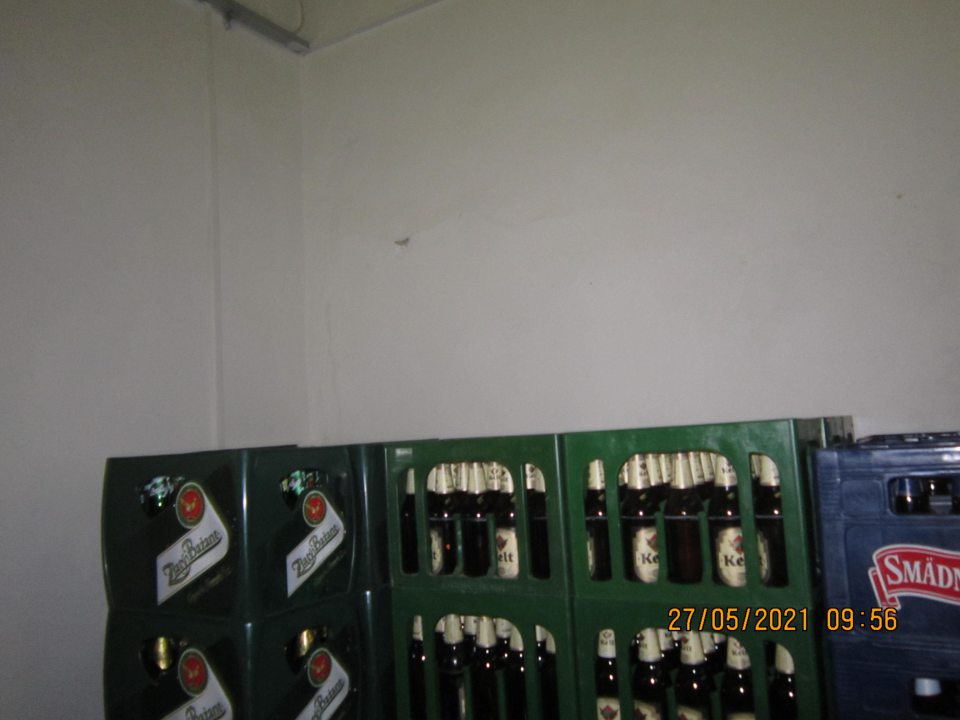 v sklade prázdnych fliaš naľavo od vstupu z prijímacieho priestoru poškodená omietka steny, vypuklá a tiež výmoľ v stene vo vydutej časti