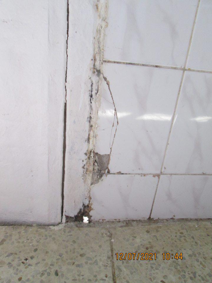 poškodený keramický obklad steny v spodnej časti pri veľkých vstupných dverách oproti etážovým peciam s výskytom výtlku a v spodnej časti s výskytom diery do vonkajšieho prostredia