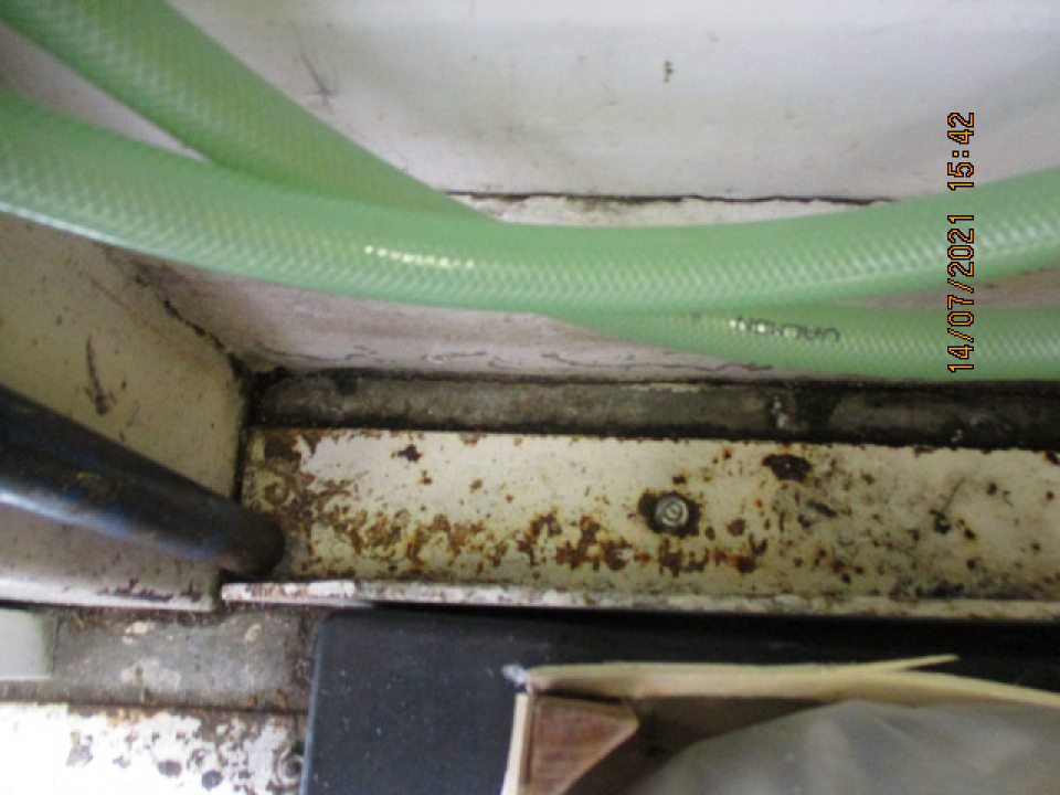 v zázemí v blízkosti príjmovej rampy na podlahe kovová lišta s výskytom korozie a olupujúci sa povrch podložky