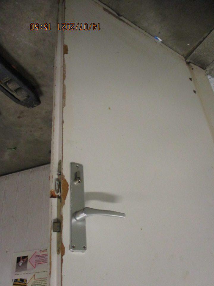 v zázemí dvere s nápisom chodba šatňové skrinky z vonkajšej strany poškodený opotrebovaný obvod dverí od kľučky po spodnú časť, vnútorná strana dverí po obvode poškodený povrch dverí