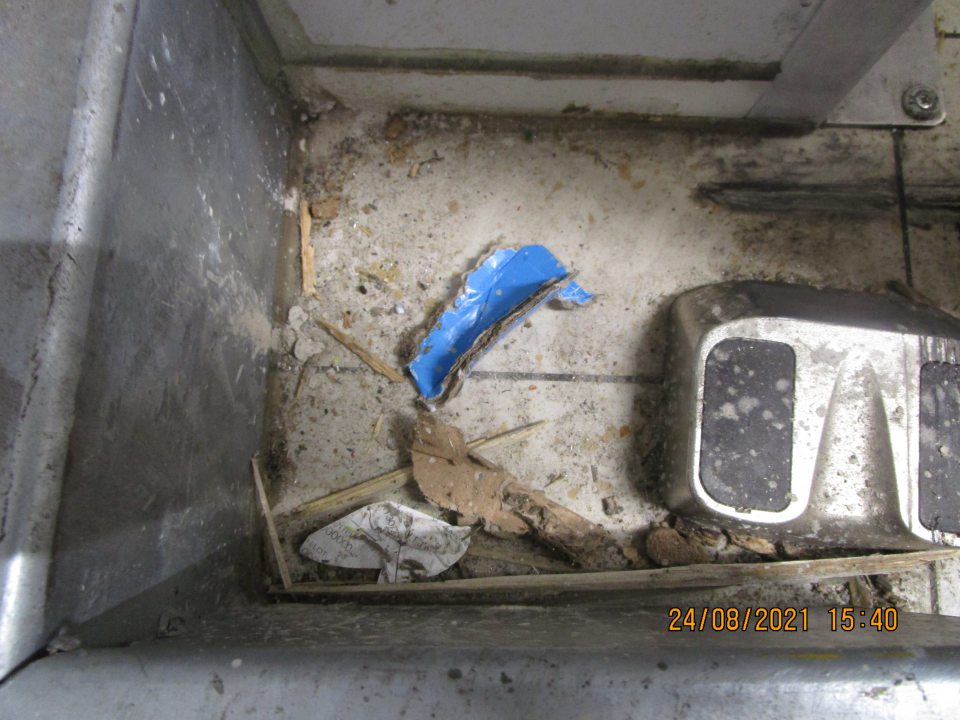 pri chladiacom boxe v prednej časti znečistená podlaha s výskytom útržkov papierov na podlahe, nánosom špiny, výskytom triesok z paliet a útržkami z obalov 