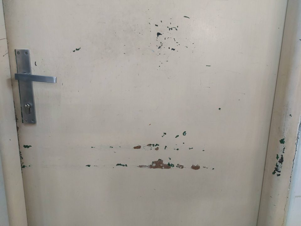 Na predajnej ploche vstupné dvere do kancelárie vedúcej prevádzky sú poškodené, neudržiavané(olúpaná farba).