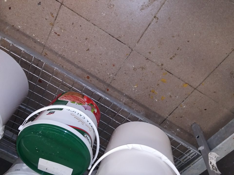 Prachom a zvyškami surovín znečistená podlaha vo výrobnom priestore.