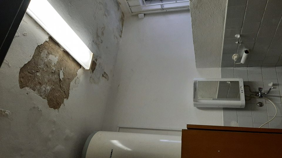 Poškodený strop v šatni pre zamestnancov, odpadávajú z neho kúsky uvoľnenej omietky v značnej miere.