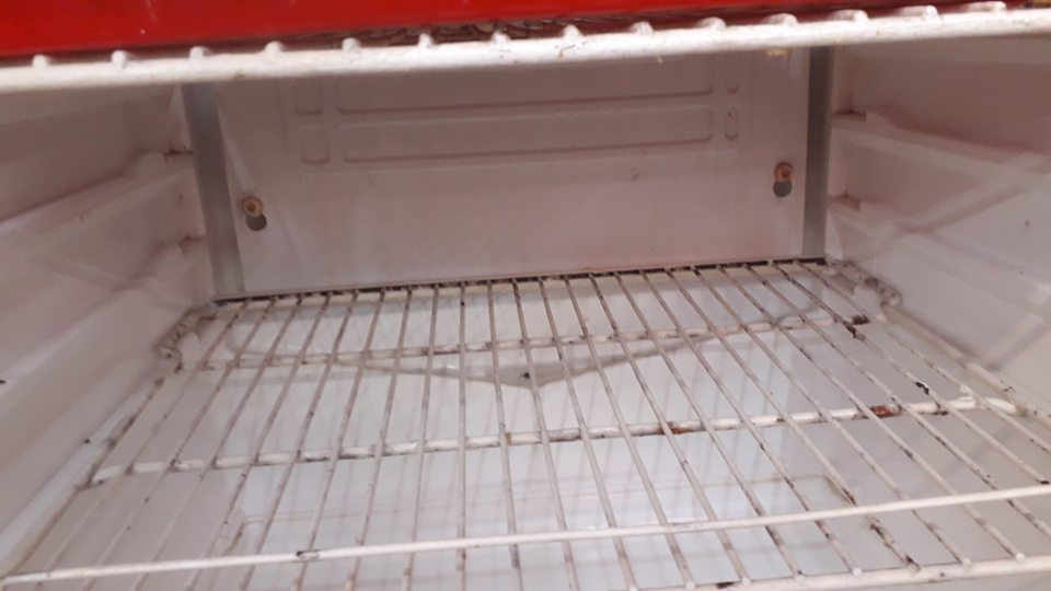 Znečistená ložná plocha - bočné steny chladiaceho zariadenia a znečistená kovová mriežka zasušenými zvyškami potravín. 