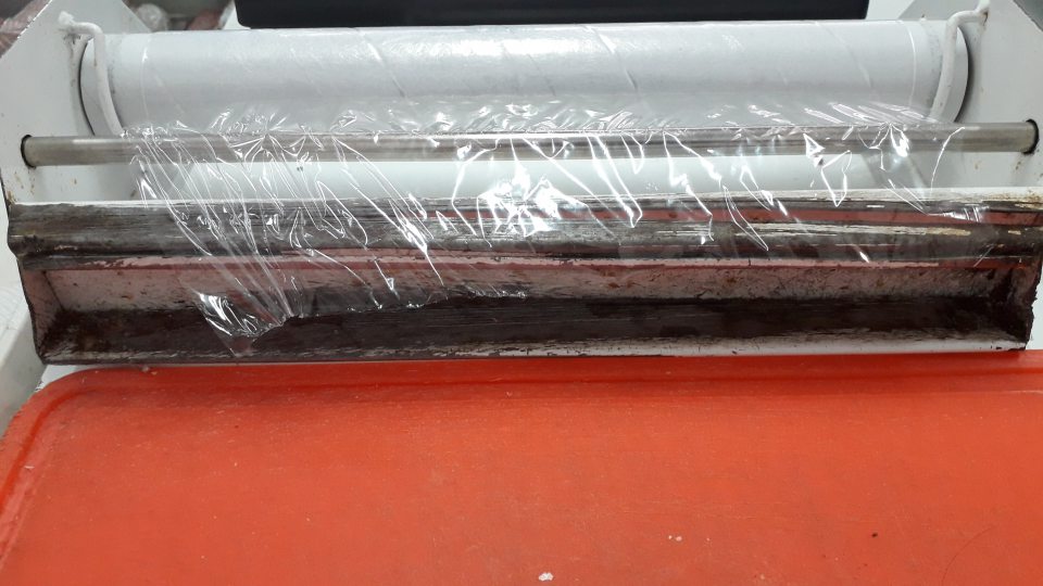 znečistený stojan na baliacu fóliu na balenie nebalených mäsových výrobkov pri predaji