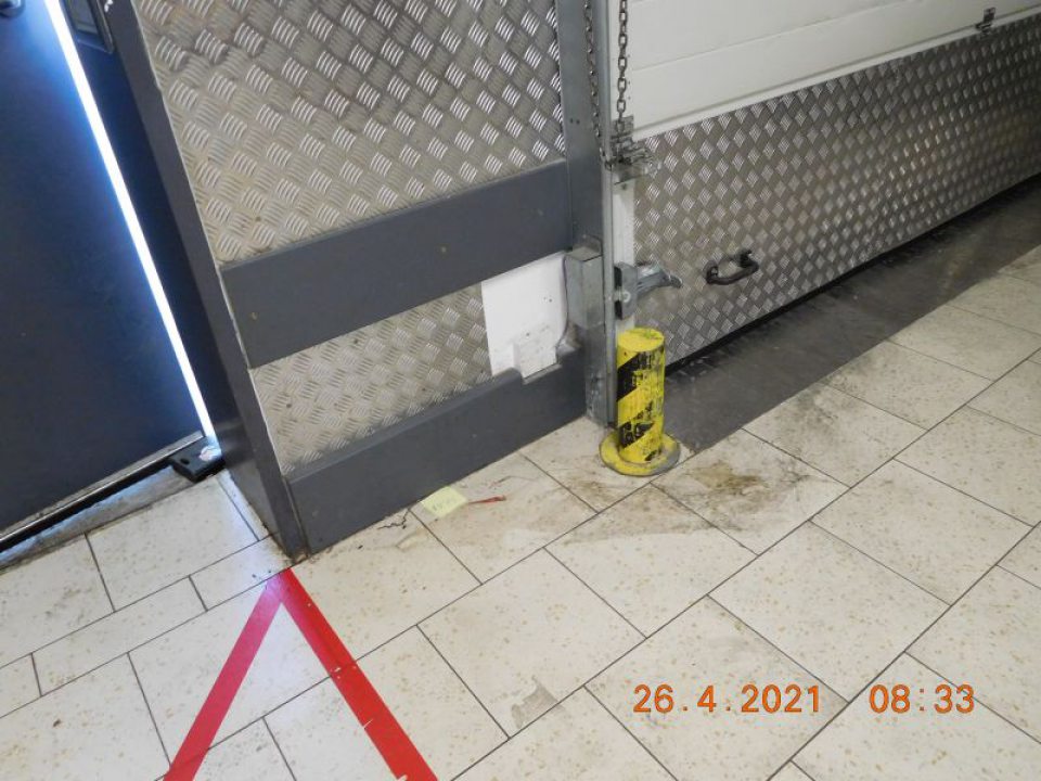 Podlaha v sklade na viacerých miestach znečistená prachom, omrvinkami, zvyškami kartónových obalov, čiernymi pásmi od manipulačných vozíkov.
