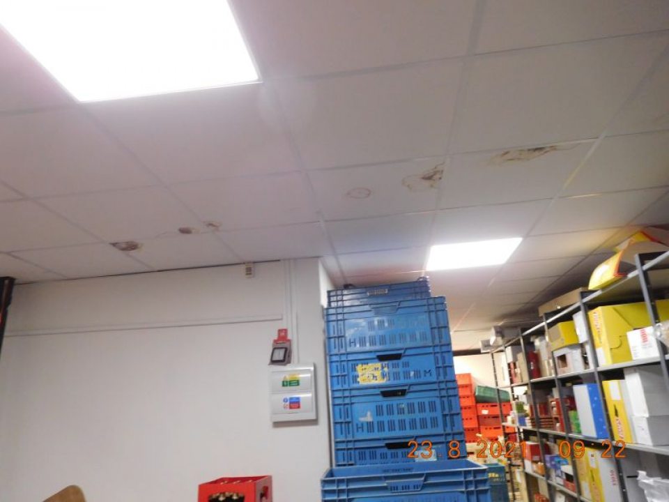 Strop v suchom sklade na viacerých miestach zatečený a znečistený nečistotou čiernej farby.