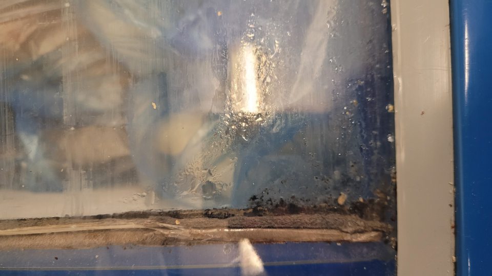 Znečistené dvierka na mraziacom boxe, v ktorom boli uskladnené hlbokomrazené pekárenské polotovary určené na dopek čiernou špinou pravdepodobne plesňou.