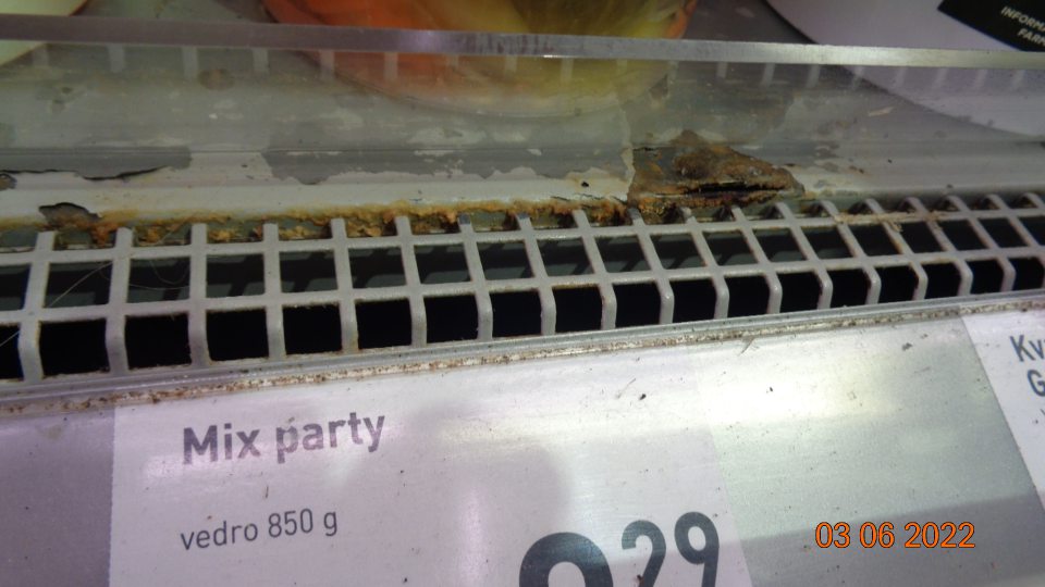 Chladiaca vitrína na predajnej ploche: v časti uloženia kvasenej kapusty a nealko nápojov v spodnej časti poškodená povrchová úprava a výrazná korózia.