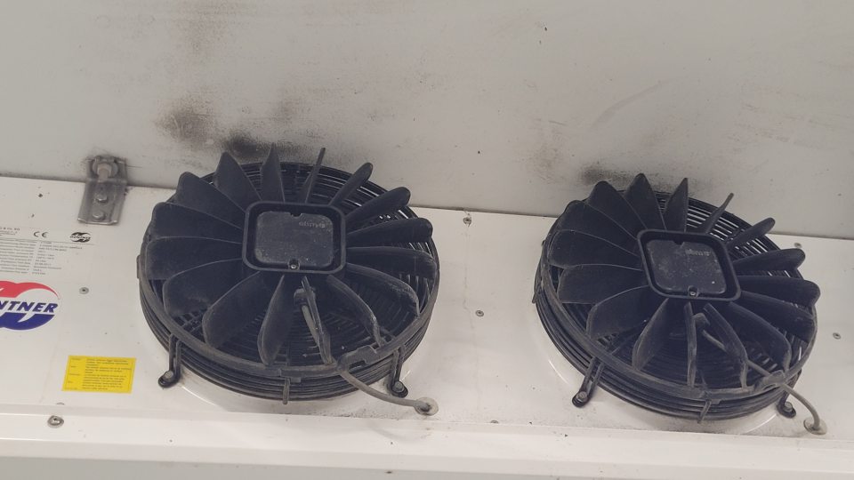 V chladiacom boxe v sklade na ovocie, zeleninu nad ventilátorom čierna špina pravdepodobne pleseň.