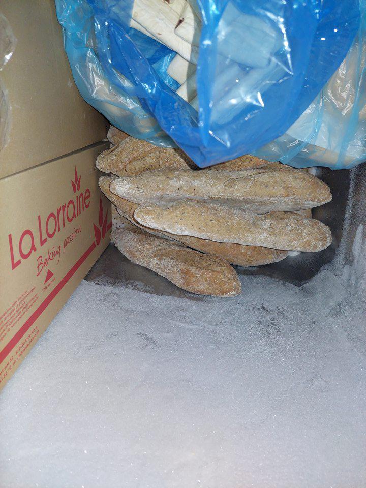 V suchom sklade v mraziacej vitríne uložené hlbokozmrazené pekárenské nepečené výrobky bez obalu.