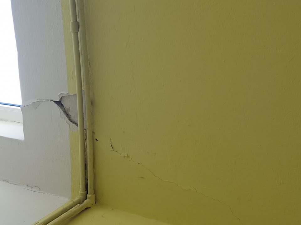 V šatni zamestnancov porušená celistvosť steny pod oknom.
