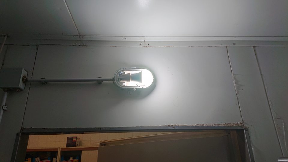 V chladiacom boxe s uskladnenými mäsovými výrobkami chýbajúci kryt na svietidle a skorodované okolie dverí.