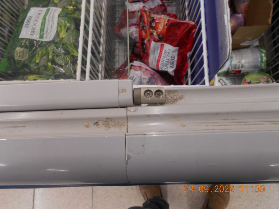 Znečistené drážky dvierok mraziarenského zariadenia s uchovávanými mrazenými krémami a mrazenou zeleninou, a to prachom. 