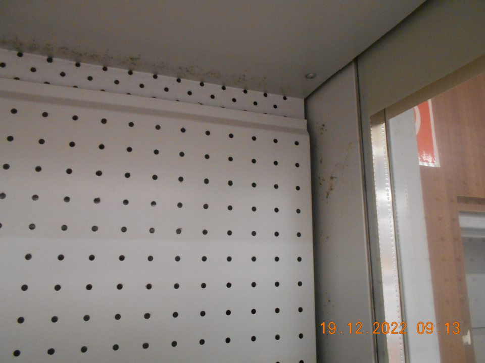 Zistená znečistená chladiarenská vitrína s uchovávanými mliečnymi výrobkami, v hornej časti. 