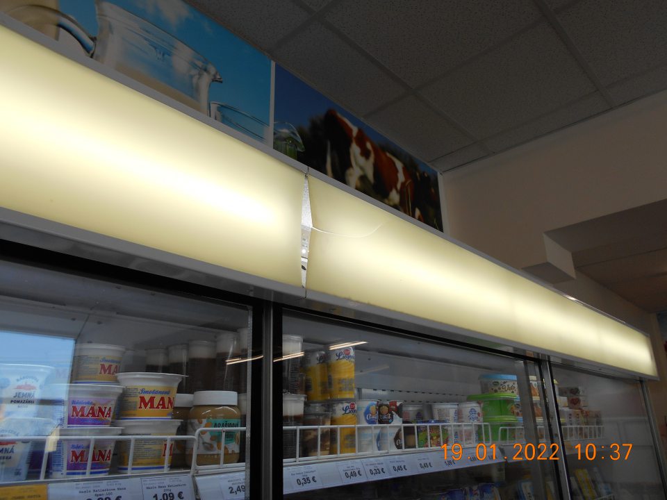  	Zistený prasknutý plastový kryt osvetlenia na chladiarenskej vitríne s uchovávanými mliečnymi výrobkami na predajnej ploche. 
