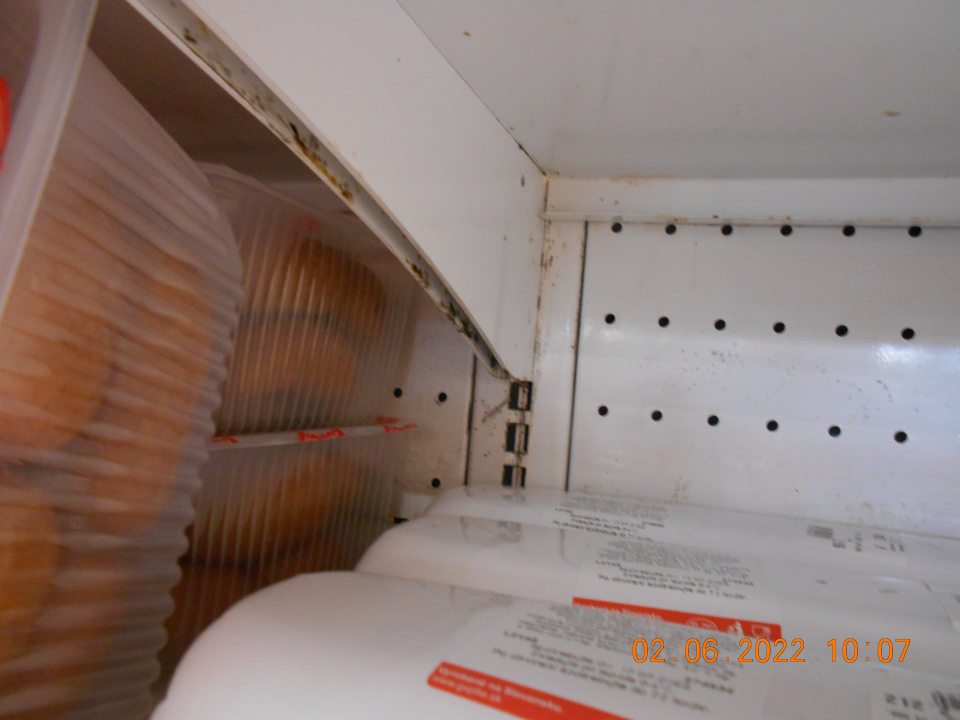  Znečistená stojacia vitrína s uchovávanými mäsovými výrobkami.