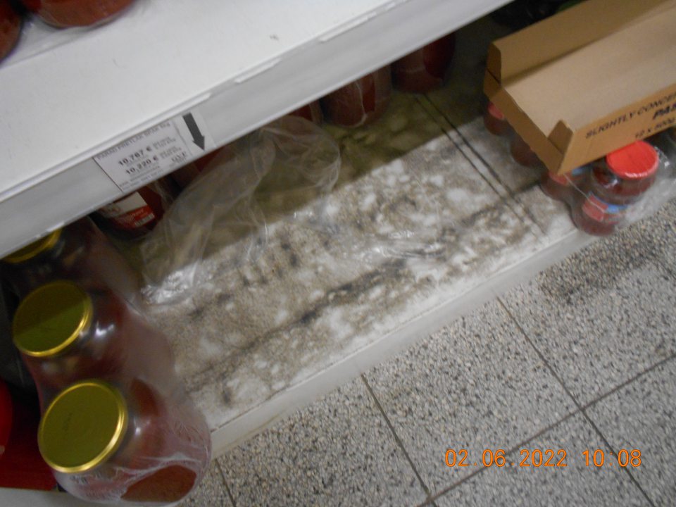  Znečistené regály s uchovávanými konzervovanými potravinami. 