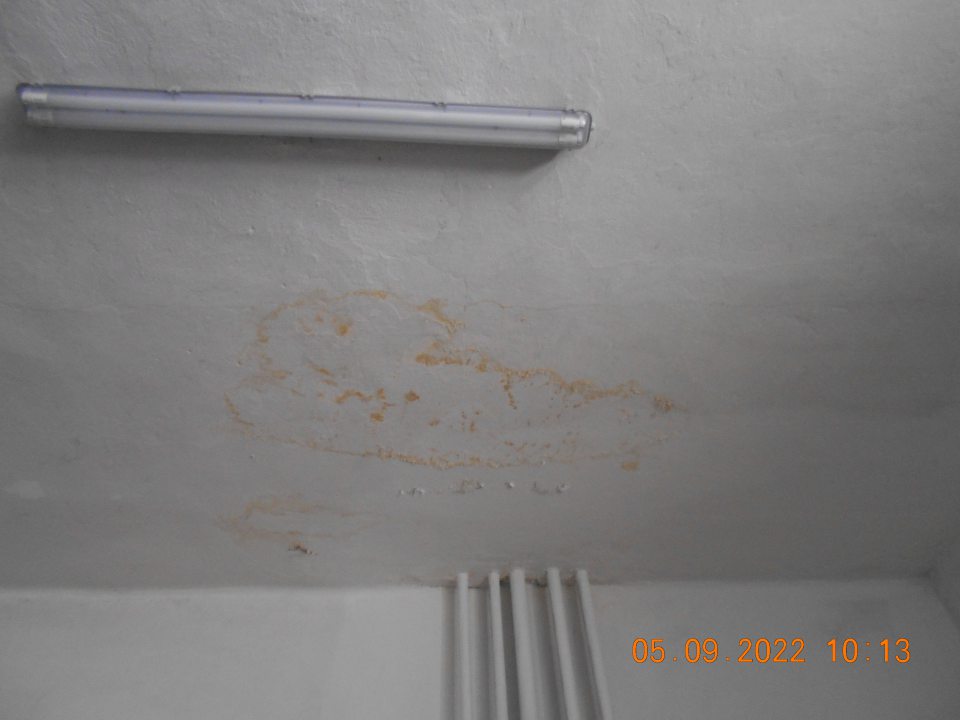 Zistený zatečený strop a olupujúca sa omietka v sklade s uchovávanými suchými potravinami.
