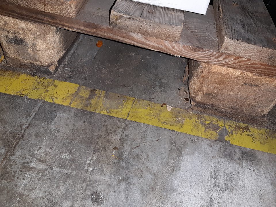 V suchom sklade znečistené podlahy, rohy, kúty, priestor pod paletami a v okolí kovových stojok regálov silno znečistené prachom a hrubou nečistotou.