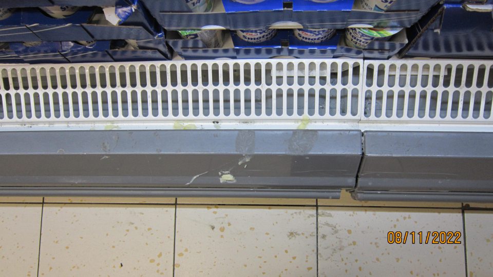 Znečistená chladiaca vitrína na mliečne výrobky v predajni