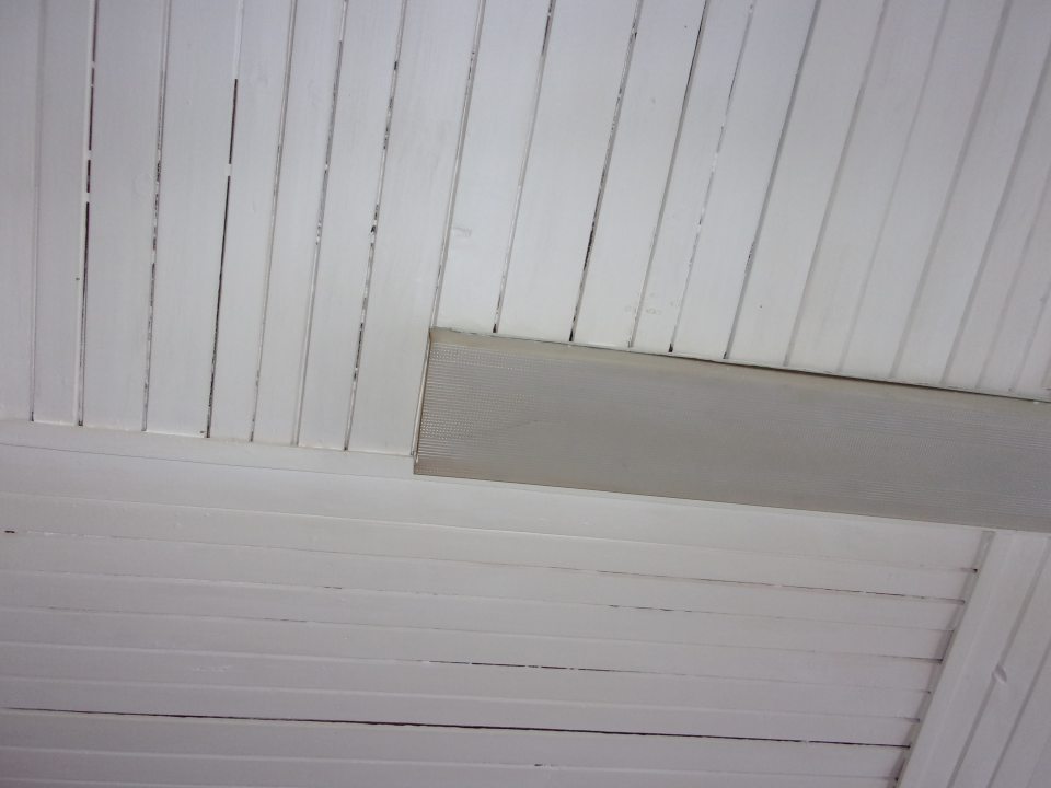 Poškodený a znečistený kryt svietidla vo výrobnej hale.