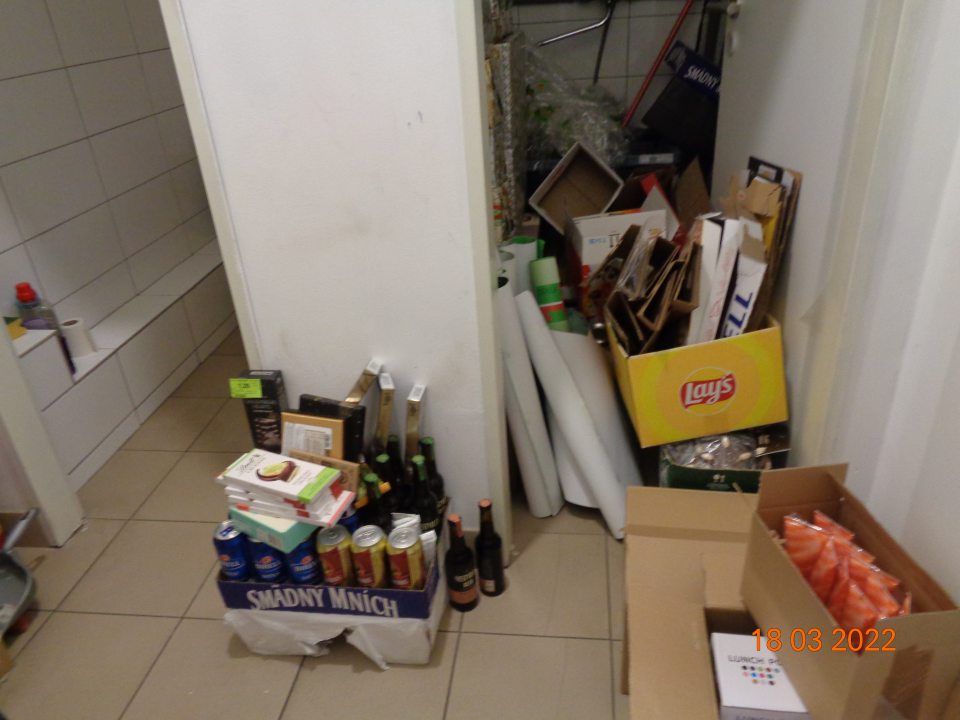 V zázemí predajne v miestnosti rozvodu a merania vody skladovaná nevyvezená kartonáž, neoznačený tovar po dátume  minimálnej trvanlivosti, dekorácie vianočnej výzdoby a reklamné plagáty.