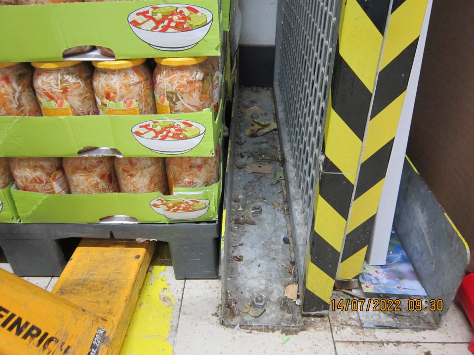 V skladovacích priestoroch v blízkosti skladovanej sterilizovanej  zeleniny uloženej na drevenej palete podlaha znečistená prachom, nánosmi zaschnutej špiny, kúskami papiera a kúskami kartóna.