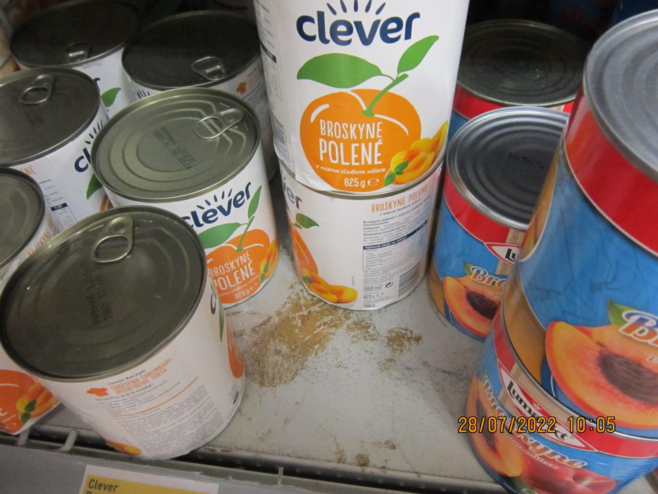 Znečistené regále na predajnej  ploche na uchovávanie sterilizovaného ovocia a zeleniny – zaschnuté nečistoty z vytečeného obsahu z daných výrobkov. 