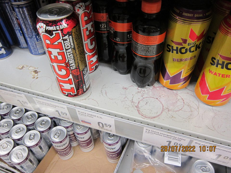 Znečistené regále na predajnej  ploche na uchovávanie nealkoholických nápojov – zaschnuté nečistoty z vytečeného obsahu z daných výrobkov a kúsky prilepeného kartóna na regáloch.