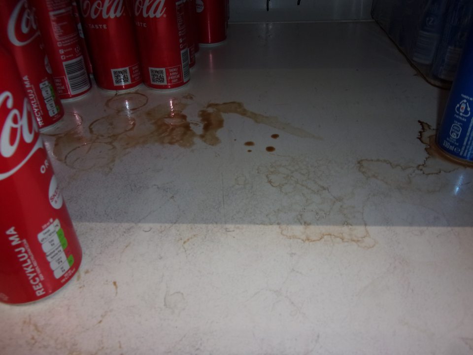 Nevyhovujúci hygienický stav regálu na predajnej ploche slúžiaceho na uchovávanie nealko nápojov  - povrch regálu znečistený zvyškami po potečení výrobkov.