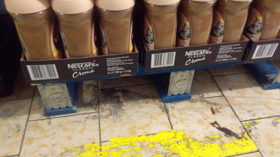 Znečistená podlaha v okolí paliet v zázemí predajne.