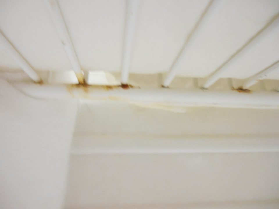 Mriežky, na ktorých sú výrobky uložené na podložke z plexiskla, sú poškodené začínajúcou hrdzou.