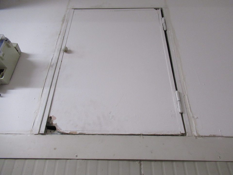 Porušená celistvosť steny v priestore nad vstupnými dverami do "Chladeného skladu mliečnych výrobkov" - dvierka s porušenou celistvosťou. 