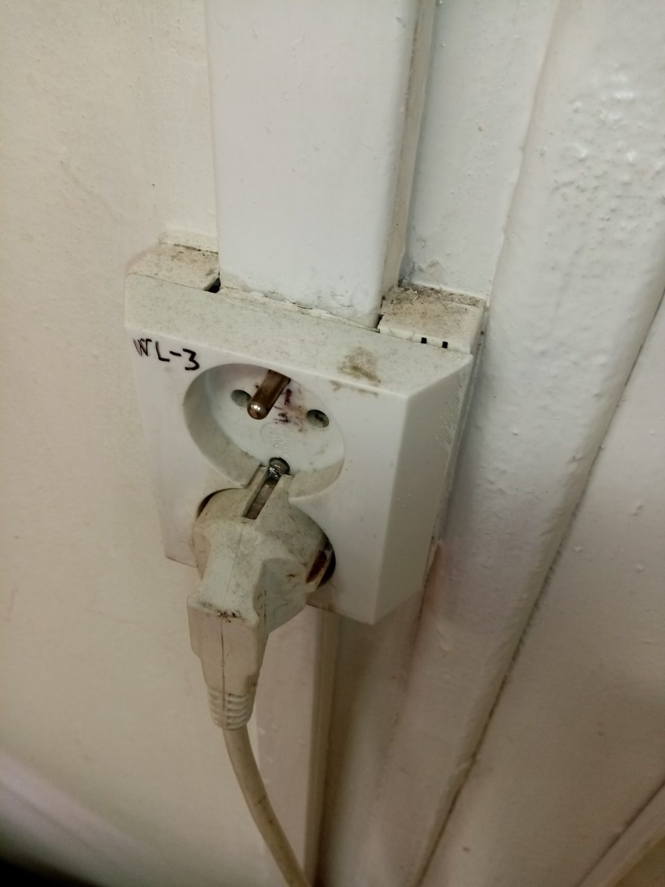 Znečistená elektrická zásuvka hrubou vrstvou prachu.