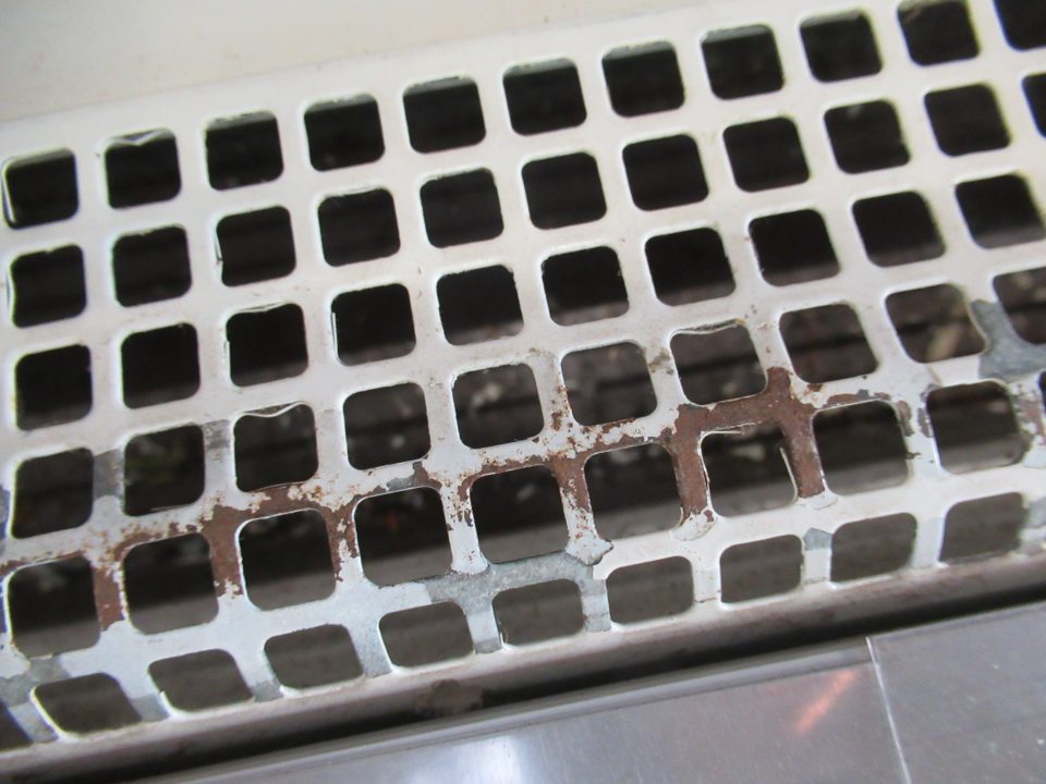 Znečistenie v prednej časti pod mriežkou nečistotami, prachom, olúpenou farbou z mriežky. Začínajúca korózia mriežky. 