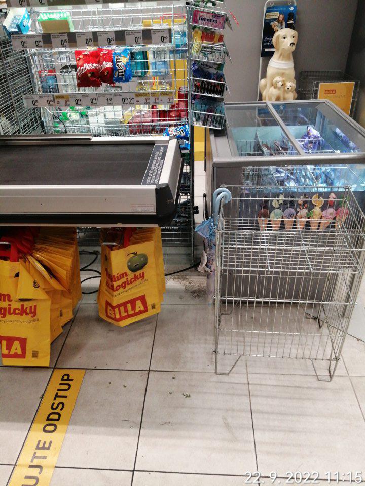 Znečistená podlaha od zatečenia pri pokladni pri mraziacom boxe na predajnej ploche od prachu a mechanických nečistôt