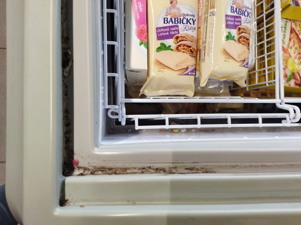 Znečistené mraziace zariadenia nečistotami a rozsypaným obsahom potravín pri predaji potravín.