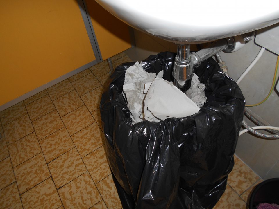 Neuzatvárateľná nádoba na odpad v predsieni záchodu.