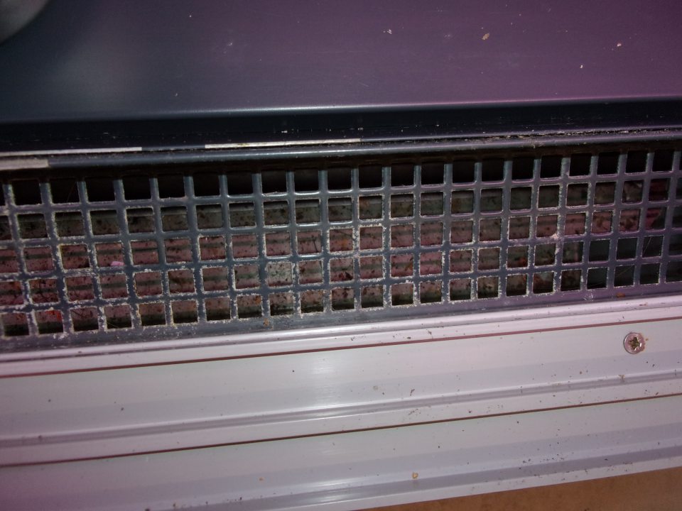 Znečistený priestor pod mriežkami v chladničke na mäsové výrobky .